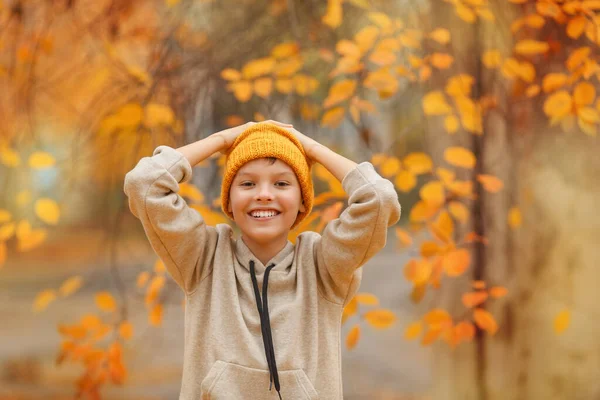 베이지 스웨터를 모자를 은가을에 앞에서 양손을 들었다 아이가 아름다운 있습니다 — 스톡 사진