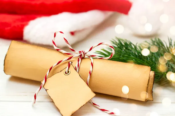Masanın üzerinde kurdeleli ve Noel Baba şapkalı bir rulo kağıt var.