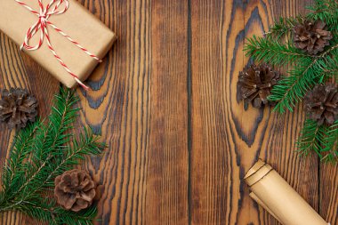 Ladin dalları, hediye ve ahşap bir arka planda bir rulo kağıt..