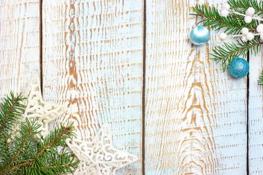 Köknar dalları ve Noel süslemeleri olan mavi ahşap arkaplan