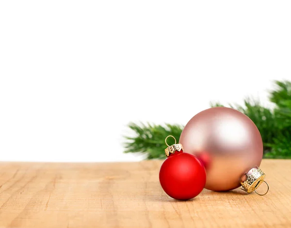 Beyaz arka planda ahşap yüzeyde pembe ve kırmızı Noel süslemeleri