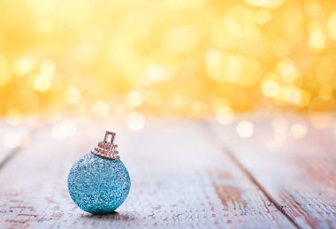 açık ahşap bir yüzeyde mavi parlak noel süsü