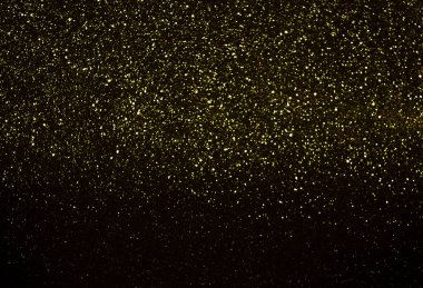 Siyah arka planda sarı parıltılar. Soyut arkaplan
