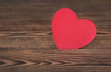 paper red heart on wooden background closeup
