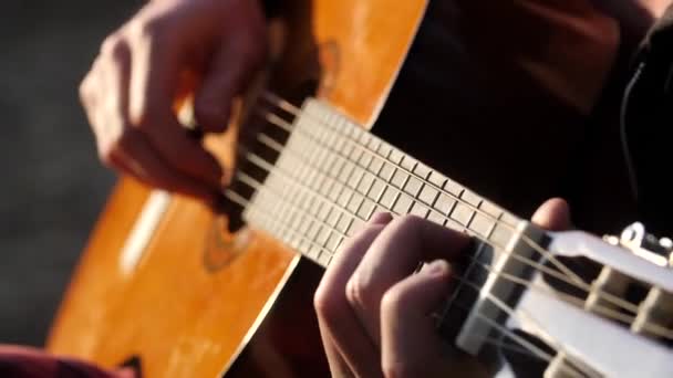 Primer plano de los dedos de los músicos rasguñando en cuerdas de guitarra acústica. — Vídeo de stock