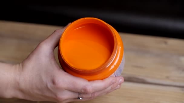 被女画家手拿着一个敞开的橙色油漆罐子开枪射击 — 图库视频影像