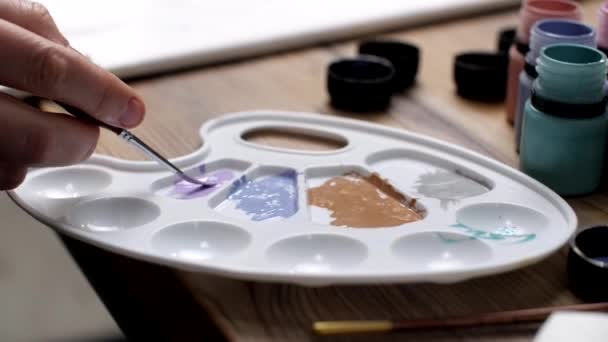 画家的刷子浸渍在调色板上的油漆中 — 图库视频影像