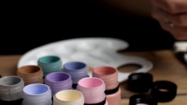 Arka planda boş bir plastik palet var. Açık boya kavanozları..