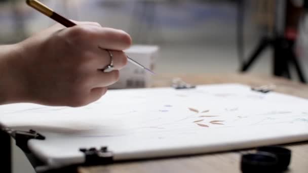 A mão feminina do artista cuidadosamente desenha com uma escova na imagem. — Vídeo de Stock