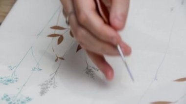 Sanatçının elinin yakın çekimi. Ressam tuvale resim yapıyor.. 