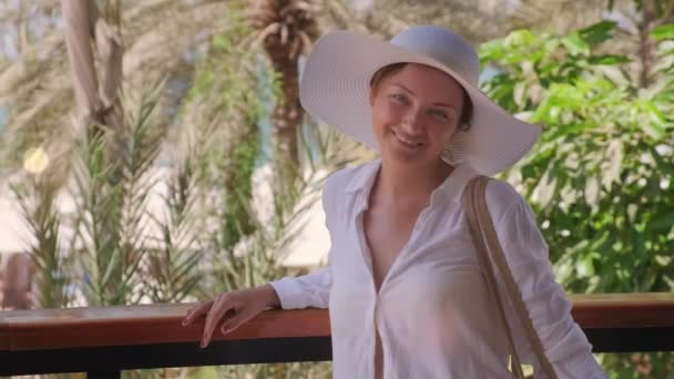 Портрет жінки у відпустці в літньому одязі на фоні пальмових дерев — стокове відео