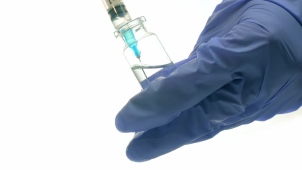 Fecskendőtű orvosi palackkal a kezében, fehér alapon izolálva — Stock videók