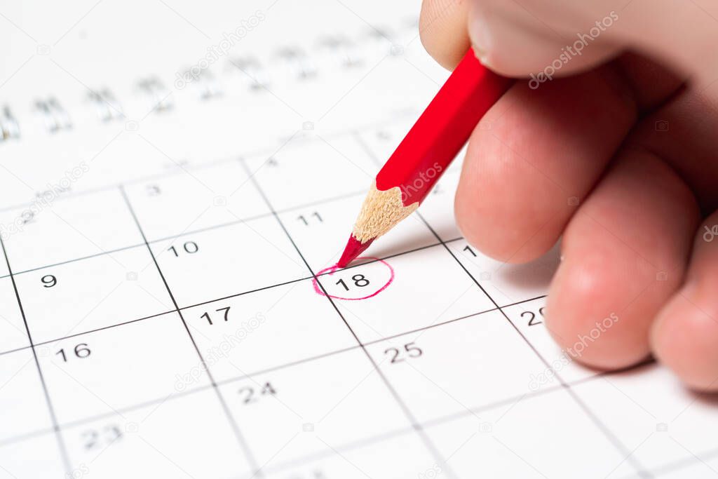 Person marks the date on the calendar with a red pencil as a reminder.