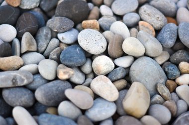 Yuvarlak çakıl taşlarıyla soyut arka plan farklı renklerde. Stones plajı pürüzsüz. Üst Manzara. Yumuşak odak.