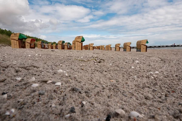 Sedie da spiaggia dalla Germania si trovano in file su una spiaggia sabbiosa, a livello del suolo colpo grandangolare. — Foto Stock