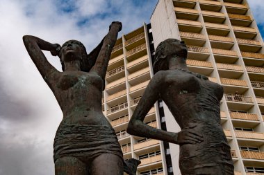 Bronz heykel, sahildeki kızlar, güney sahilindeki otel kulelerinin önünde. Burgtiefe, Fehmarn, Almanya, Avrupa