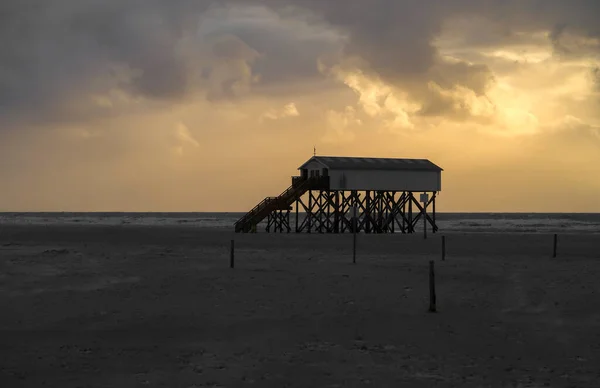 日落时在瓦登海的倾斜房子。St. Peter Ording, Nord See, Germany — 图库照片