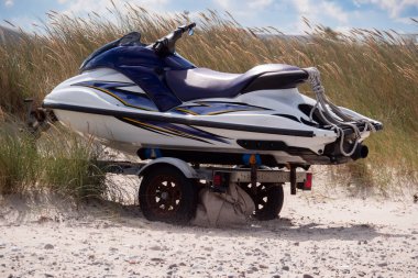 Marram Ot 'un önündeki kumlu sahilde bir nakliye karavanında jet ski.