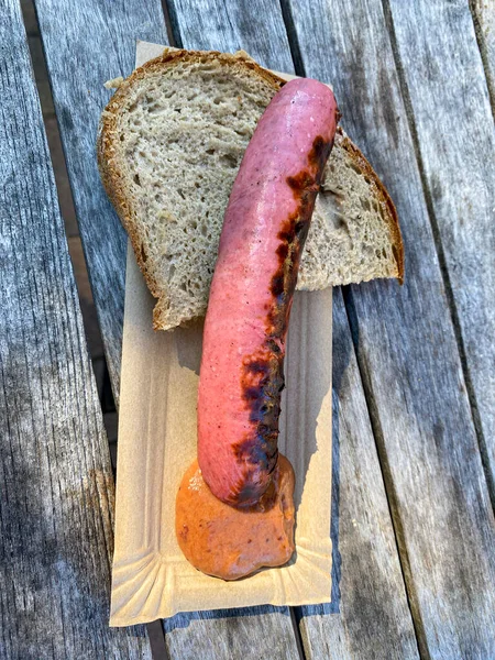 Gegrillte Erdbeerwurst auf einem Pappteller mit Senf und Brotscheibe — Stockfoto