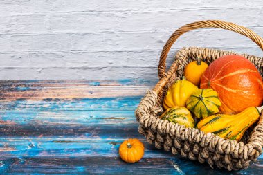 Süslü su kabaklarıyla dolu dekoratif sepet ve eski kırsal masada Hokkaido kabağı. Koleksiyonumda daha çok sonbahar ve balkabağı motifleri
