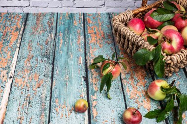 Taze kırmızı elmalarla süslü sepet eski bir masanın üstünde duruyor. Koleksiyonumda daha fazla yemek fotoğrafı