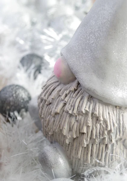 Pembe burunlu alçıdan yapılmış Noel cücesi, mücevherlerin ve zincirlerin arasında.