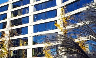 Ofis binasının maskarası, güneş gören mavi pencereli.