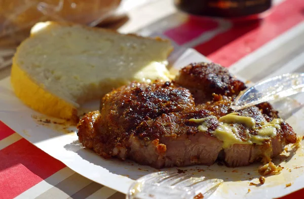 Izgara domuz boynu, bir dilim ekmek, açık hava yemeği.