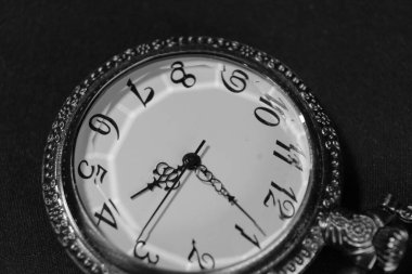 Eski cep saati yüzü, siyah beyaz fotoğraflanmış.