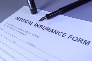 Medical Insurance Form with pen lain across the page