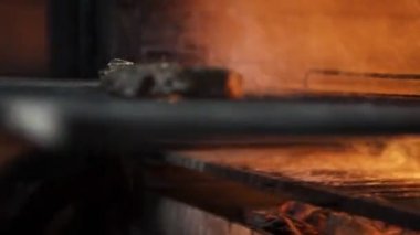Metal ızgarada ızgara biftek dumanla kızartılıyor..