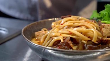 Şef restoranda udon eriştesiyle tabak süsledi. Kapat..