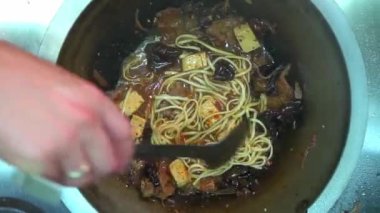 Şef, et, sebze ve soya peynirli Udon Eriştesi pişiriyor. Üst Görünüm