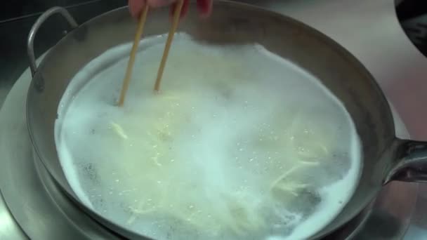 Pan con Udon Noodles bollente. Cucinare e mescolare con bastoncini di costoletta — Video Stock