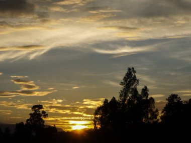 Muhteşem günbatımı sona erdi, ufukta turuncu güneş yükseliyor.