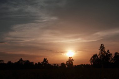 Muhteşem günbatımı sona erdi, ufukta turuncu güneş yükseliyor.
