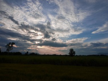 Muhteşem günbatımı sona erdi, ufukta turuncu güneş yükseliyor.