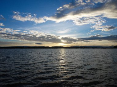 Muhteşem günbatımı sona erdi, ufukta turuncu güneş yükseliyor.