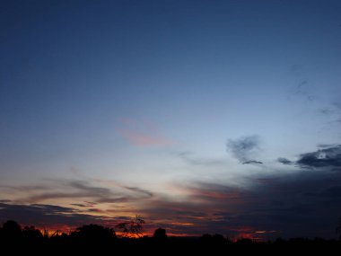 Muhteşem günbatımı sona erdi, ufukta turuncu güneş yükseliyor.