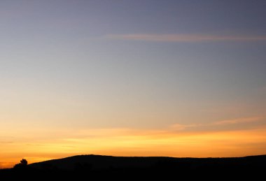 Muhteşem günbatımı sona erdi, ufukta turuncu güneş yükseliyor.