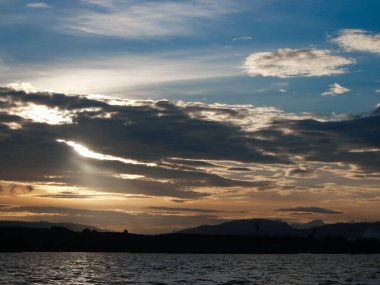 Muhteşem günbatımı sona erdi, ufukta turuncu güneş yükseliyor.