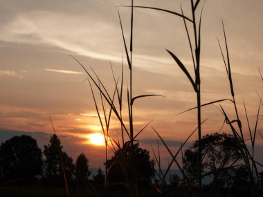 Muhteşem günbatımı sona erdi, ufukta turuncu güneş yükseliyor.