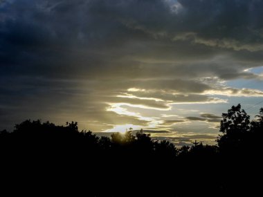 Muhteşem günbatımı sona erdi, ufukta turuncu güneş yükseliyor.