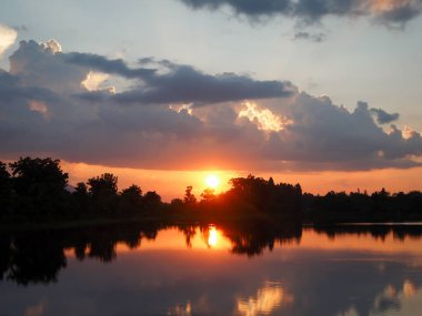 Muhteşem günbatımı sona erdi, ufukta turuncu güneş yükseliyor.