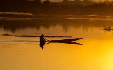 Gün batımında, nehir kıyısında parlak renkli gökyüzü