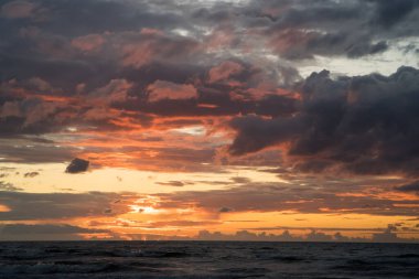Baltık Denizi üzerinde bulutların üzerinde güzel, ılık gün batımı ışığı