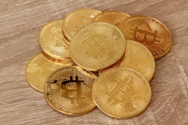 Ahşap bir masanın üzerindeki birkaç bitcoin 'in değeri şu anda artıyor ve popülerliği artıyor..