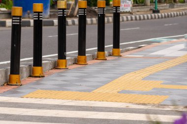 Otoyolun yanındaki kaldırımda, engelliler için sarı renkli bir yol var. Eşit haklar kavramı.