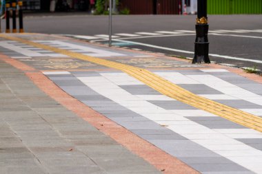 Otoyolun yanındaki kaldırımda, engelliler için sarı renkli bir yol var. Eşit haklar kavramı.