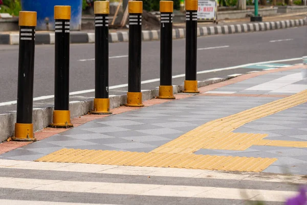 Otoyolun yanındaki kaldırımda, engelliler için sarı renkli bir yol var. Eşit haklar kavramı.
